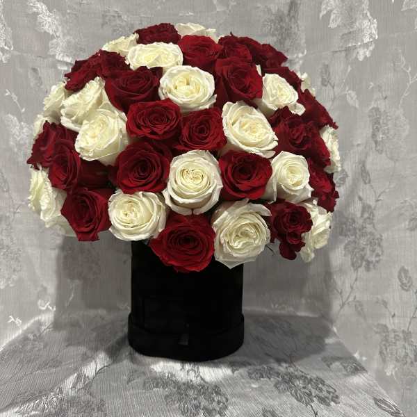 Red and white rose arrangement in a black box