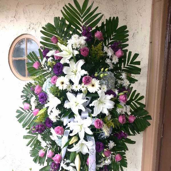 Standing floral spray with white lilies, pink roses, and purple accents