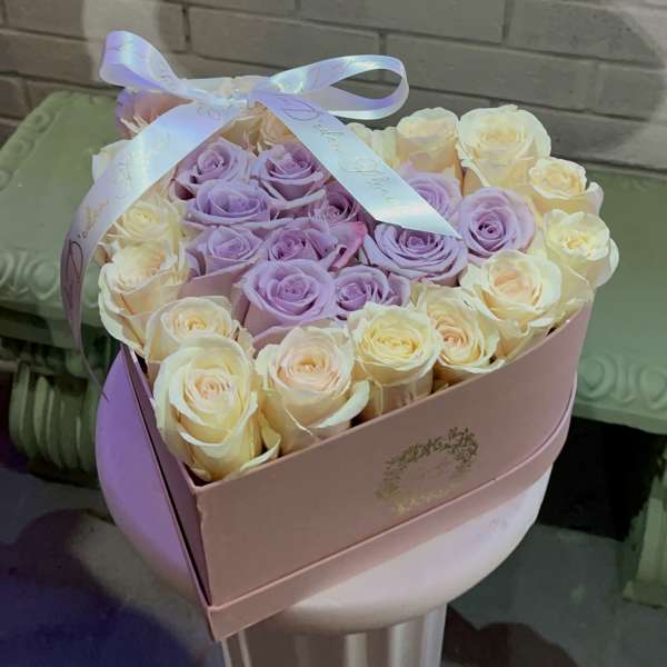 Boxed bouquet of lavender and cream roses with a ribbon bow