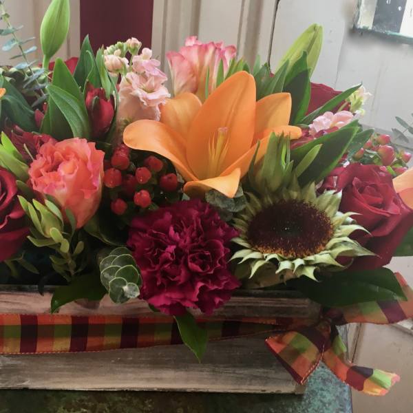 Mixed bouquet in a rustic wooden box with red roses and orange lilies