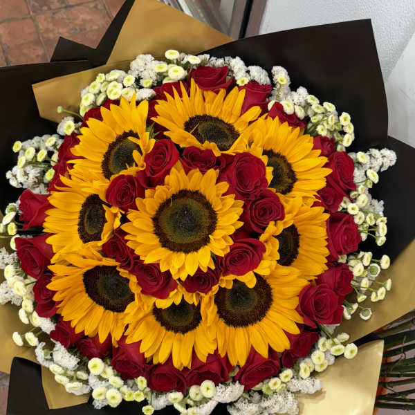 Bouquet of sunflowers and red roses wrapped in black and gold paper