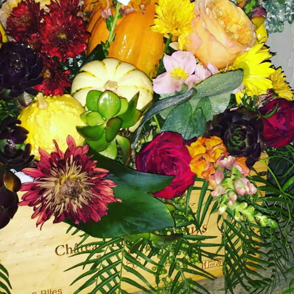 Mixed bouquet with pumpkins, roses, and chrysanthemums in a wooden box