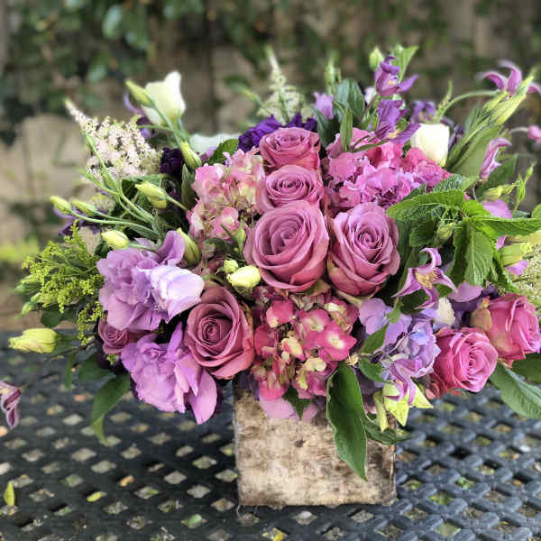 Pink and purple mixed bouquet in a rustic square container
