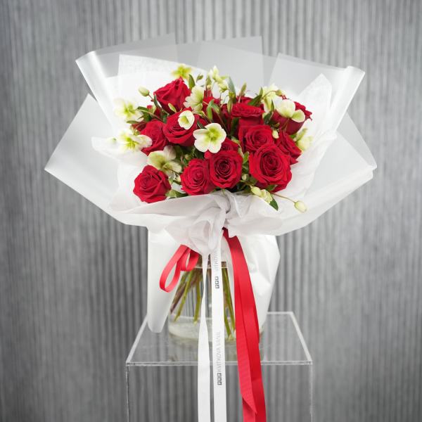Bouquet of red roses with white flowers wrapped in white paper