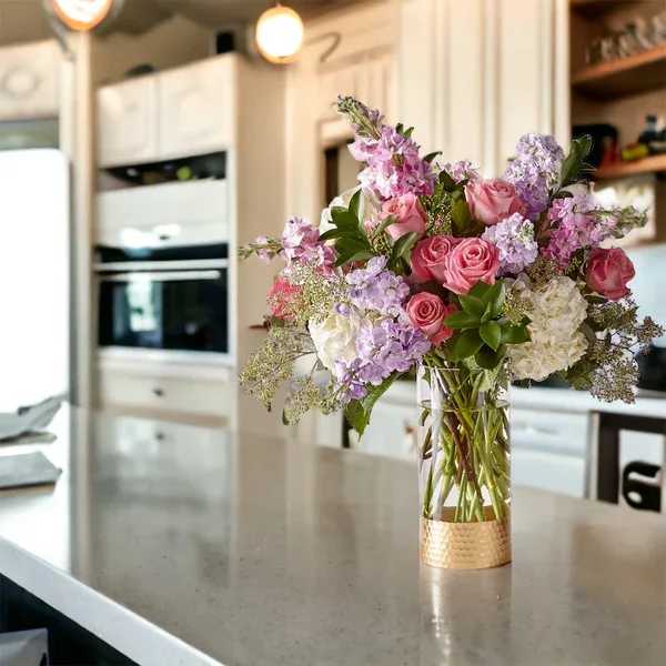 Pink and lavender flower bouquet in a clear glass vase