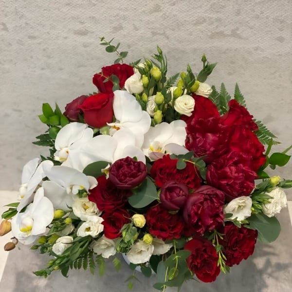 Bouquet of red roses and white orchids with greenery