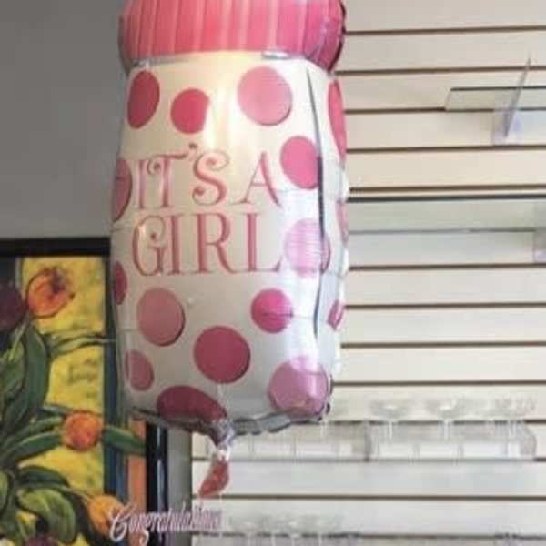 Baby bottle-shaped balloon above a diaper cake wrapped in clear plastic