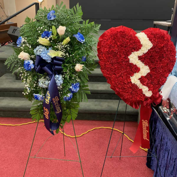 Two standing floral funeral sprays, one heart-shaped red wreath with a white crack