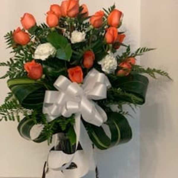 Orange rose bouquet with white flowers and a white ribbon