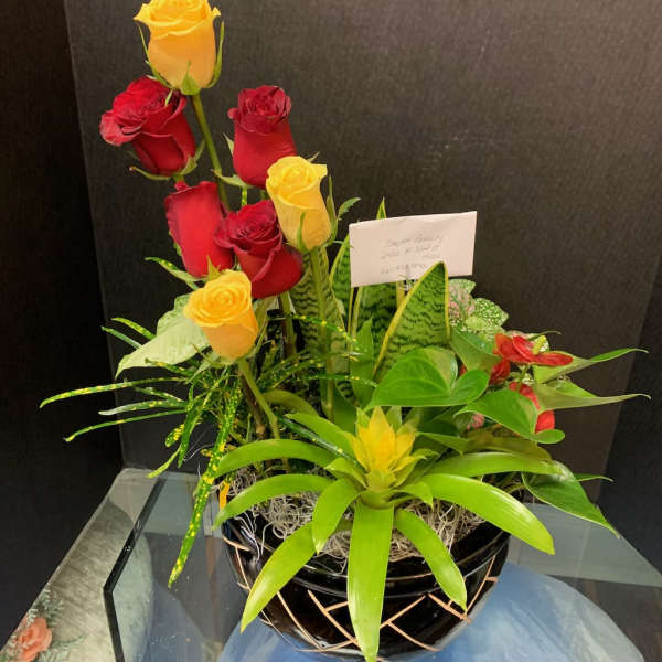 Arrangement of red and yellow roses in a black basket