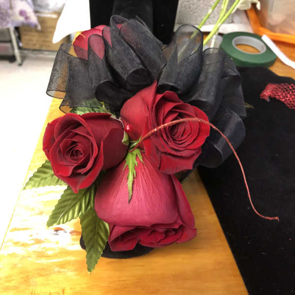 Red roses with black ribbon in a small bouquet