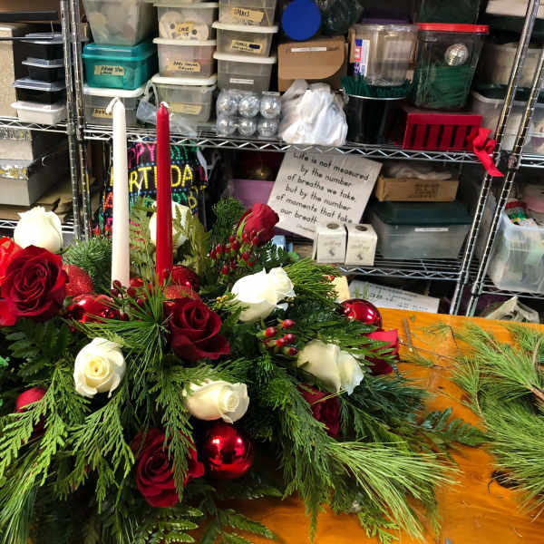 Holiday centerpiece with red and white roses and two taper candles