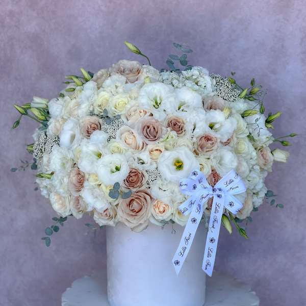 Large white and blush bouquet in a white vase with a ribbon bow