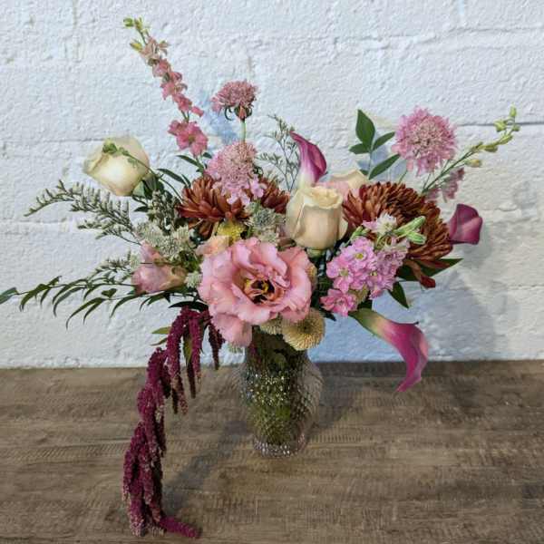 Mixed pink and cream floral arrangement in a glass vase