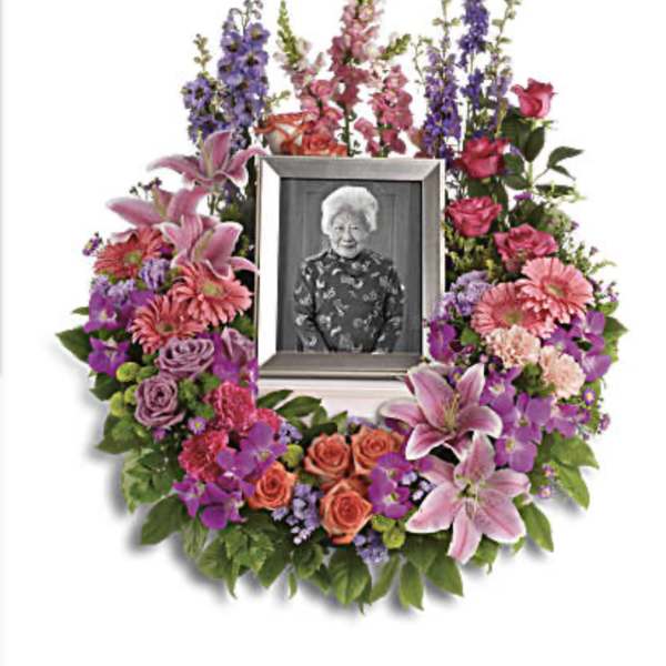 Floral memorial wreath with a framed photo in the center