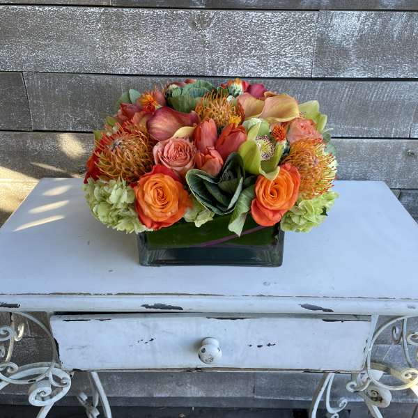 Bright mixed bouquet in a square glass vase