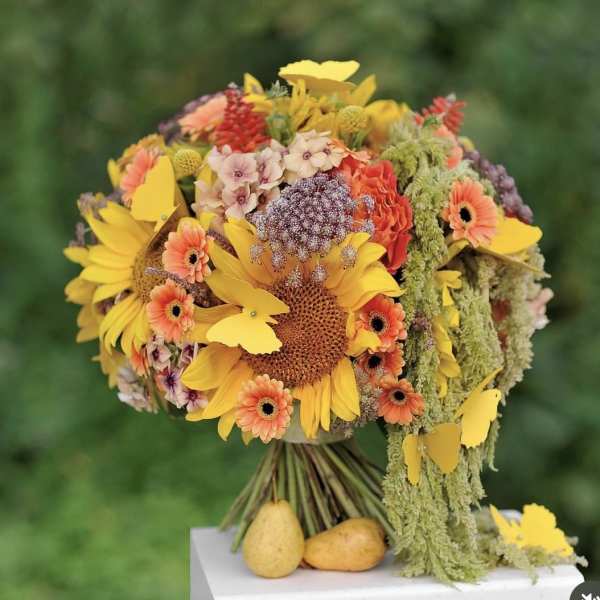 Bouquet of sunflowers and orange flowers with hanging green filler