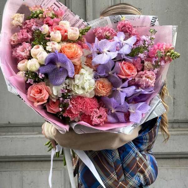 Large bouquet of pink and purple flowers wrapped in paper