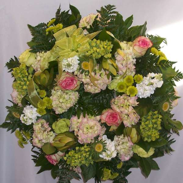 Round floral spray with pink roses, pale hydrangeas, and white blooms