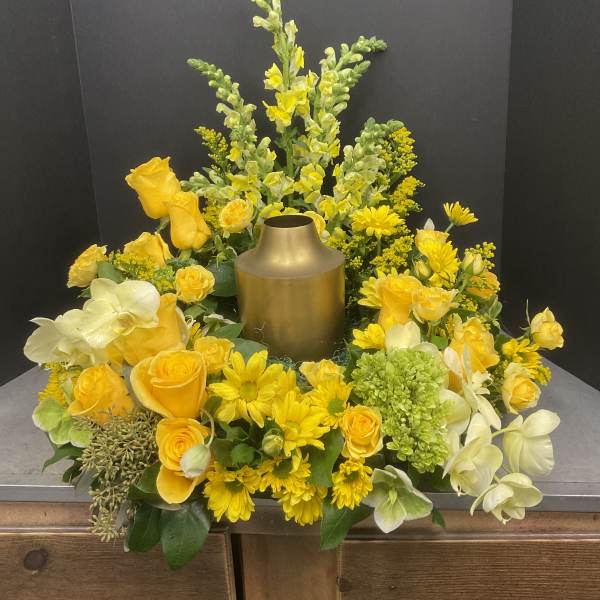 Yellow floral arrangement around a gold urn