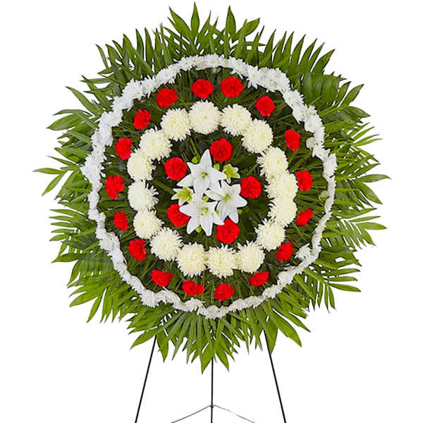 Circular funeral wreath with red and white flowers on a stand