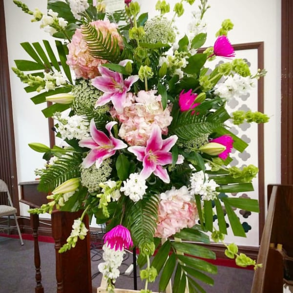 Tall standing floral spray with pink lilies, white blooms, and green accents