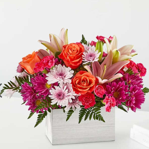 Mixed bouquet of roses, lilies, and daisies in a white box