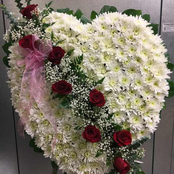 Heart-shaped white chrysanthemum arrangement with red roses and pink ribbon