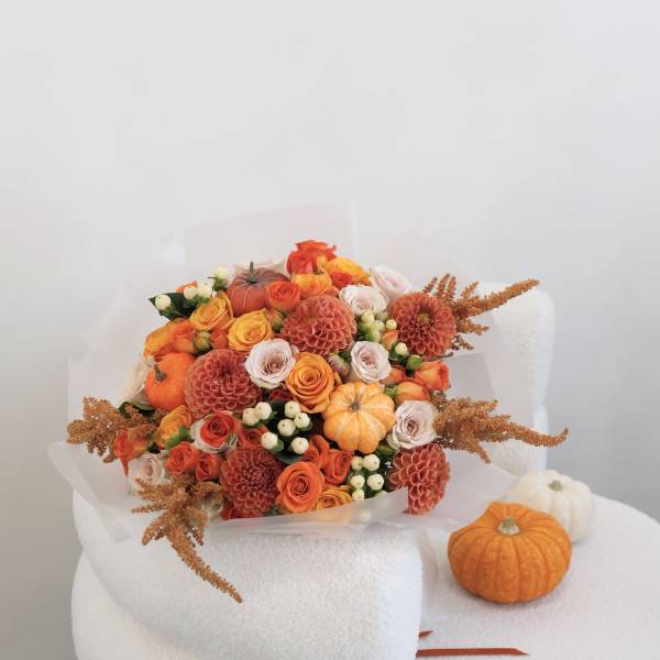 Orange and peach bouquet with small pumpkins on a white chair