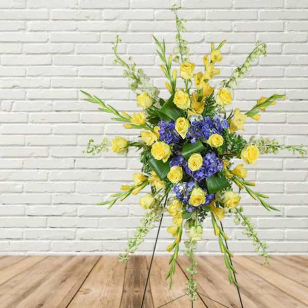 Yellow and blue floral standing arrangement on a metal easel