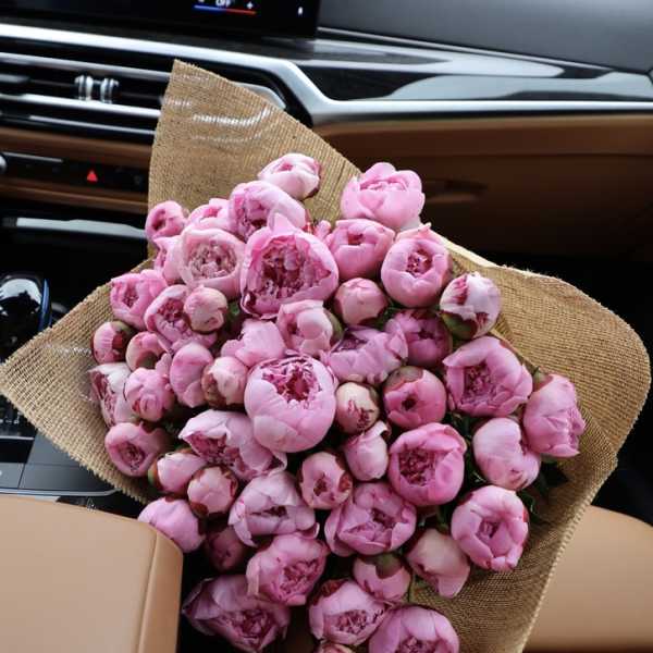 Bouquet of pink peonies wrapped in burlap