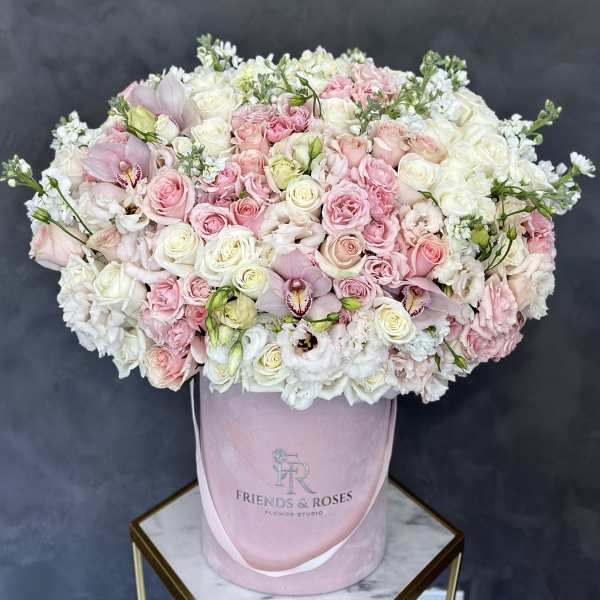 Pink and white roses with orchids in a pink hatbox