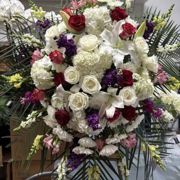 Large white and red floral standing arrangement with lilies and roses