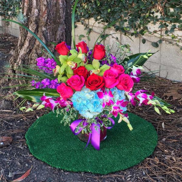 Bright mixed bouquet with roses, orchids, and hydrangea in a vase