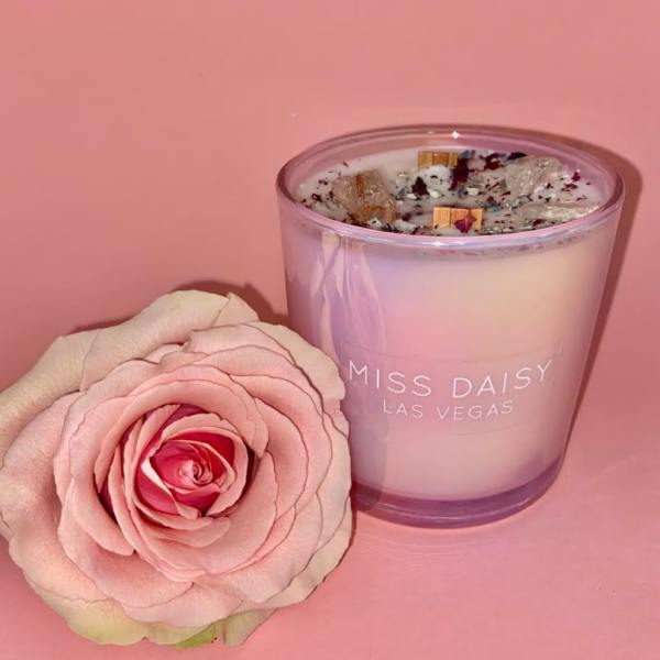 Pink rose beside a lavender glass candle with "Miss Daisy Las Vegas" text
