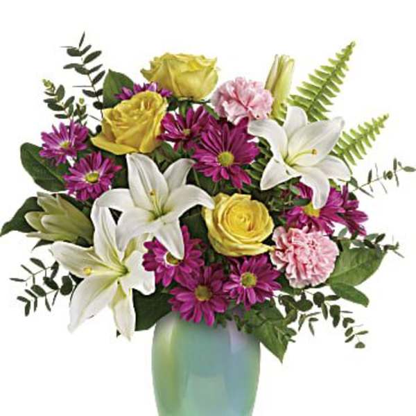 Bouquet of white lilies, yellow roses, and purple daisies in a green vase