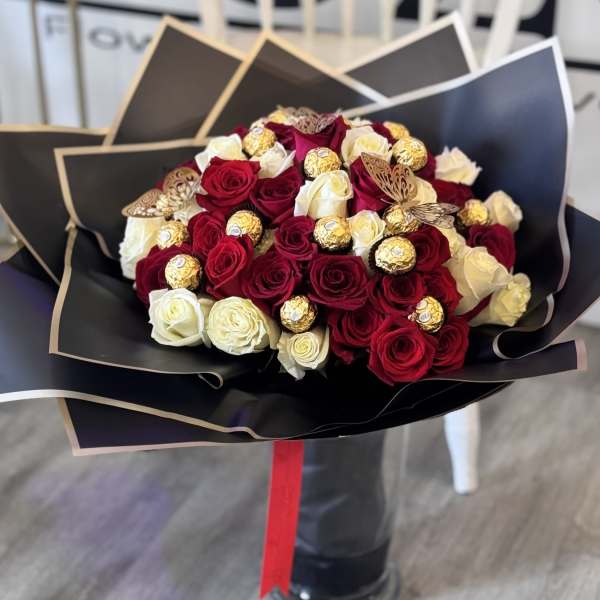 Bouquet of red and white roses with gold-wrapped chocolates