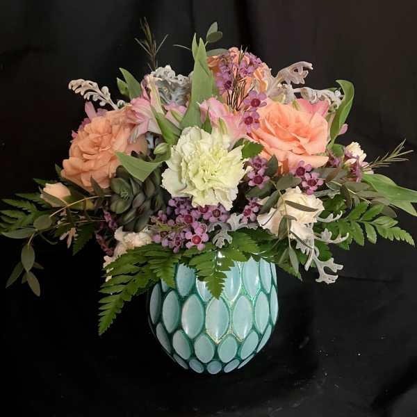 Mixed bouquet in a turquoise mosaic vase with peach, pink, and white flowers