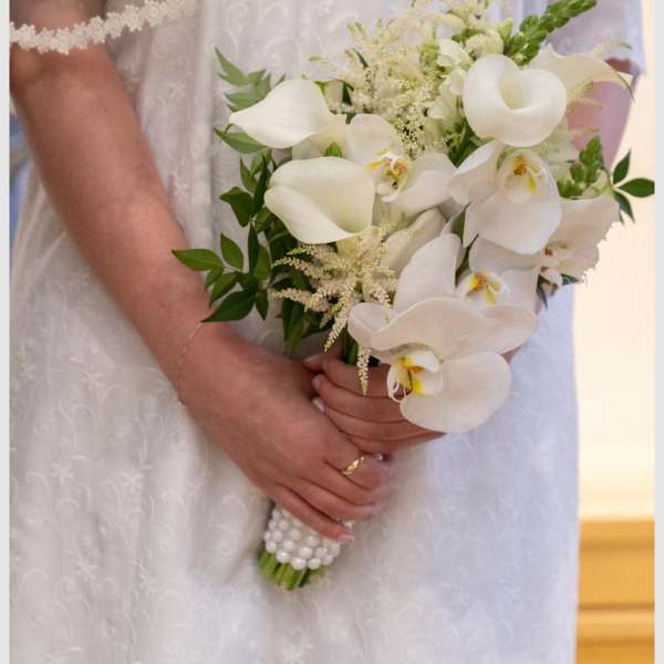Bride holding a white calla lily and orchid bouquet