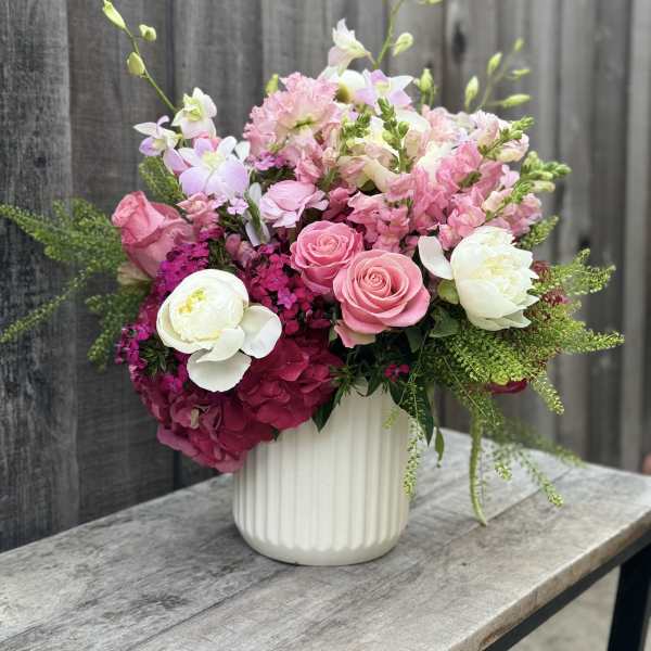 Pink and white floral arrangement in a white vase