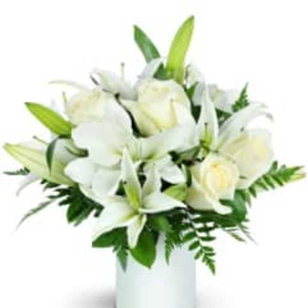 White lilies and roses in a white vase
