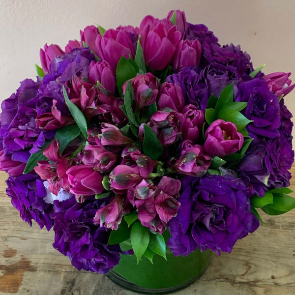 Purple and pink bouquet in a green vase
