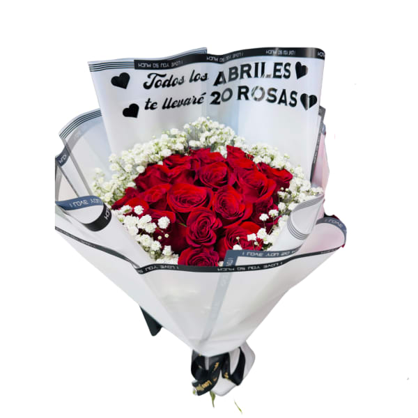Bouquet of red roses with white filler flowers wrapped in white paper with a Spanish love message.
