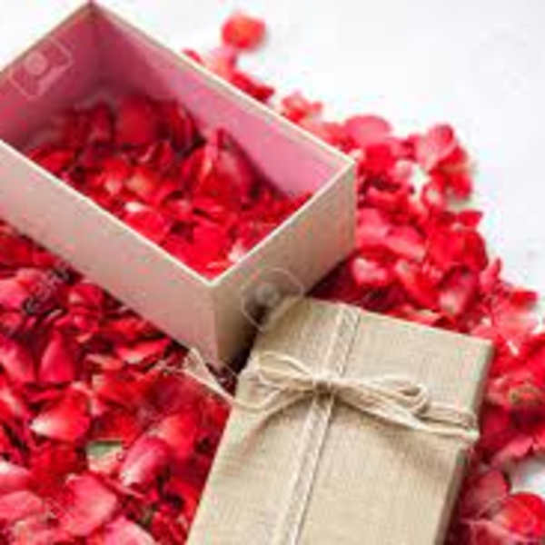 Gift boxes surrounded by red rose petals