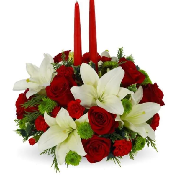 Red roses and white lilies arranged with two red taper candles