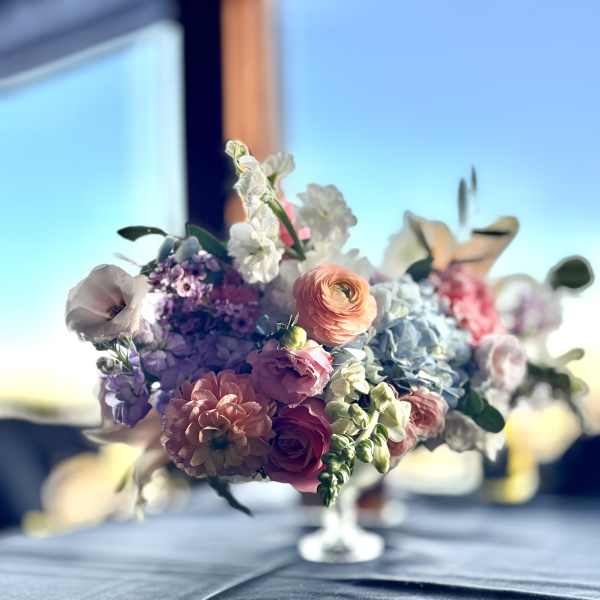 Pastel bouquet with roses, ranunculus, and hydrangeas in a glass vase
