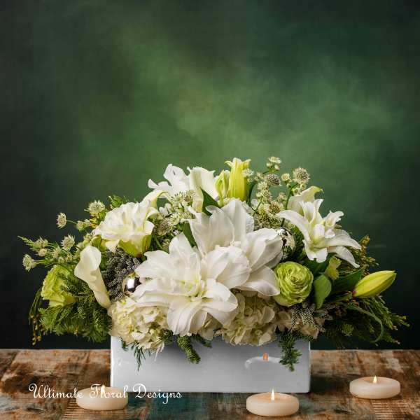 White lilies and calla lilies arranged in a white rectangular vase