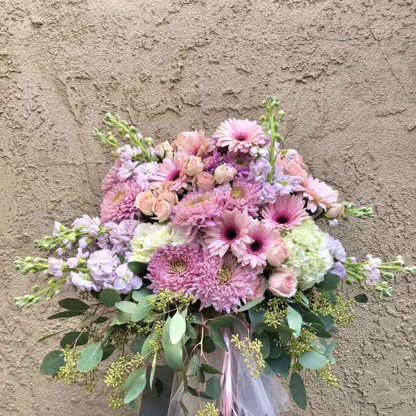 Pink and lavender bouquet with roses and daisies in a ribbon-tied arrangement
