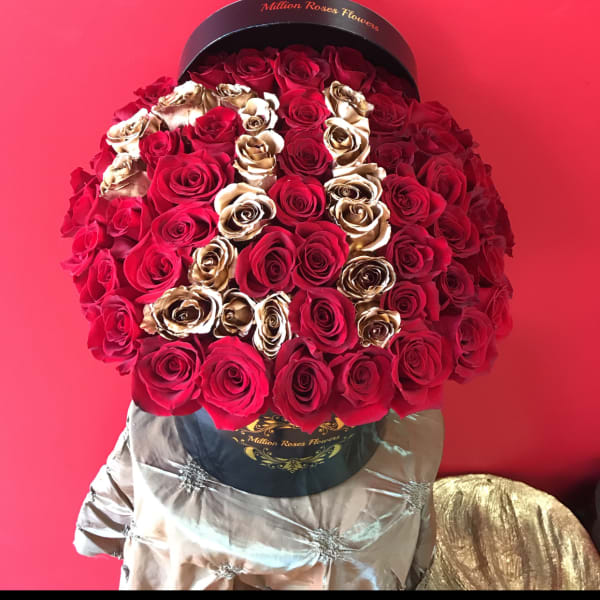 Large bouquet of red and gold roses in a black hatbox