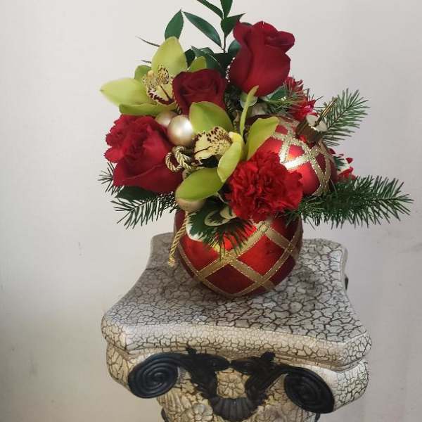 Red roses and green orchids in a red ornament vase